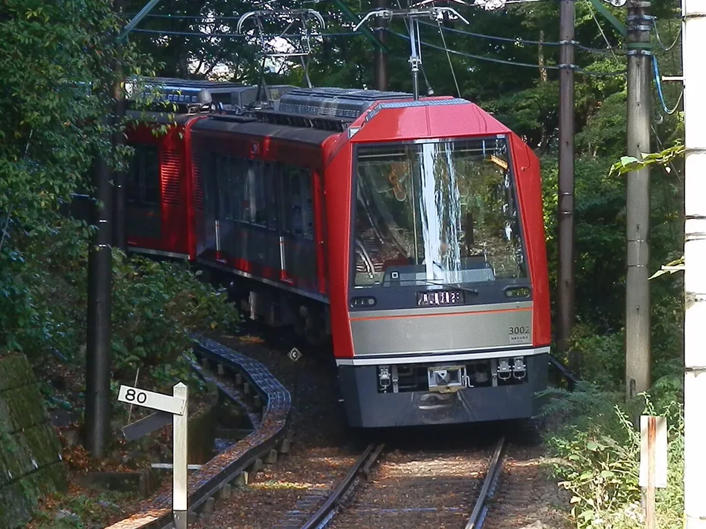 红色箱根登山 Allegra 电车在绿色山林线路中